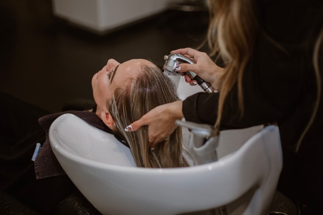 The hairdresser washes the head of a girl