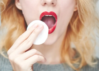 Girl wipes lipstick with a cotton pad